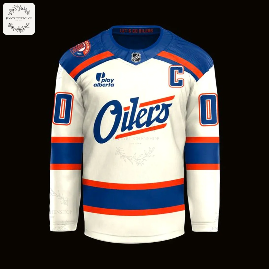 A close-up of the front of the white Edmonton Oilers 2025 jersey, showing the script logo, captain's C, and blue and orange stripes.