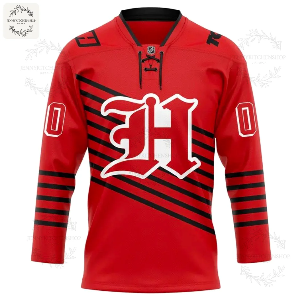 Front of the red Huntsville Havoc retro hockey jersey, featuring a white and black gothic 'H' logo and black diagonal stripes.