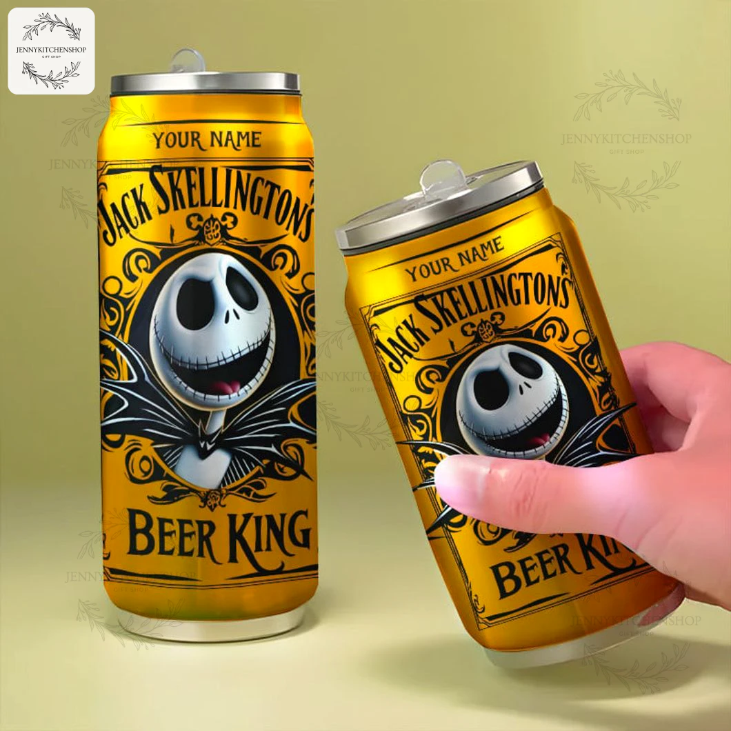 Two gold Jack Skellington can tumblers on a neutral surface, one upright and one tilted and held by a hand to show scale, showcasing the front artwork, "Beer King" text and customizable name area.